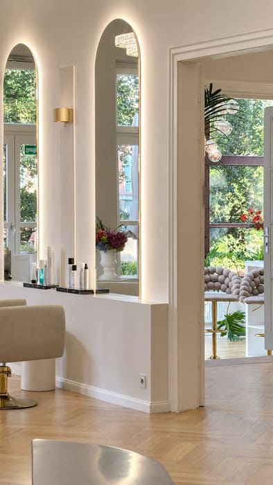 Salon mit Rundbogenspiegeln und Blick in den Wintergarten