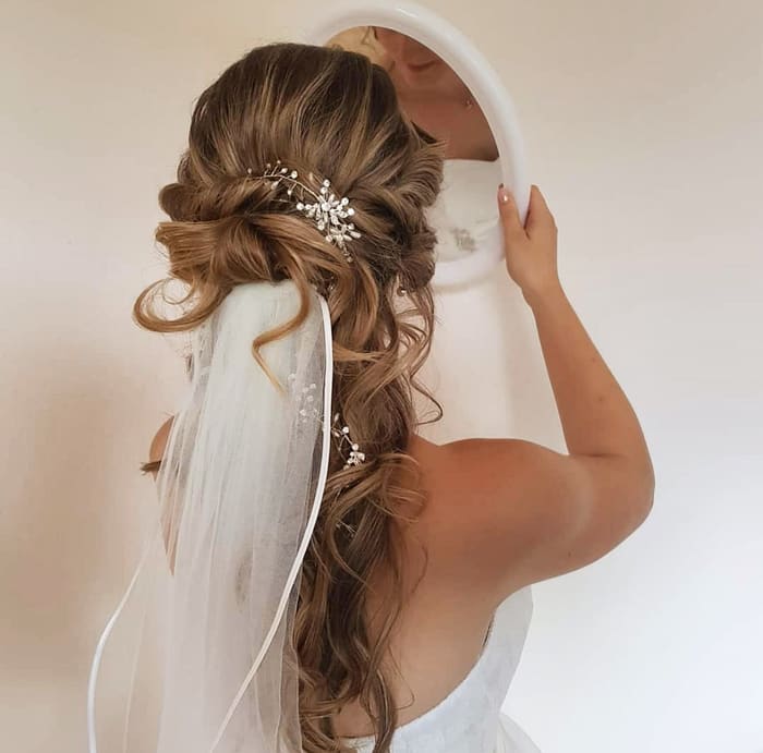Brautfrisur mit Schleier und Haarschmuck, von hinten vor dem Spiegel